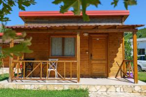 a log cabin with a deck and a table at Bunec Beach Resort in Piqeras