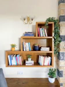 un estante de libros con libros y plantas. en Tour House, A Country Escape set in Natures Beauty, en Youghal