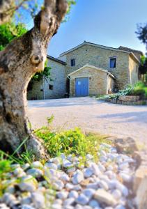 a tree in front of a building with a garage at Antico Borgo in Arcevia