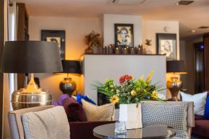 a living room with a table and chairs at Hôtel Des Gouverneurs in Bastia