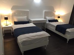 een kamer met twee bedden en twee tafels en lampen bij Hotel International in Međugorje