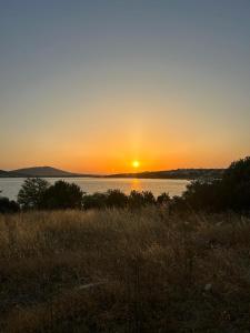 una puesta de sol sobre un cuerpo de agua con la puesta de sol en Modern Studio Apartment with Garden en Ayvalık