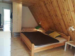 two beds in a room with wooden walls at Chalupa Varechovsky potok in Vysoká nad Kysucou