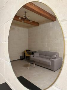 a living room with a couch and a mirror at Sea Holly Gozo in Nadur