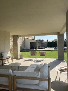 a patio with couches and tables in a yard at Finca Clos in Borrassá