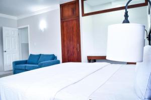 a bedroom with a bed and a blue chair at JamGolia Place in Mandeville