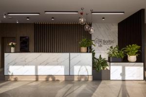 a lobby with a counter with potted plants on it at Hotel Saltic Resort & Spa Grzybowo in Kołobrzeg +114 photos