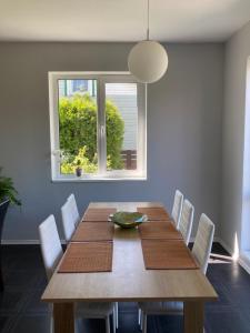 mesa de comedor con sillas blancas y ventana en Holiday House near beach, en Liepāja