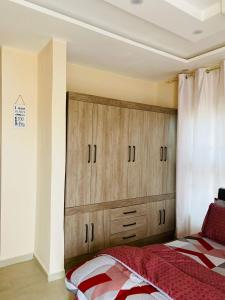 ein Schlafzimmer mit einem Bett und einem großen Holzschrank in der Unterkunft Virgin Island resort in Ada