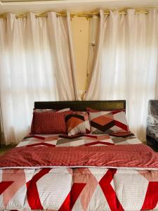 ein Bett mit einer roten und weißen Decke drauf in der Unterkunft Virgin Island resort in Ada