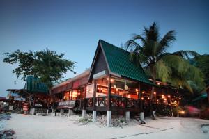 a building with a green roof on the beach at Tuna Bay Island Resort in Perhentian Islands +35 photos