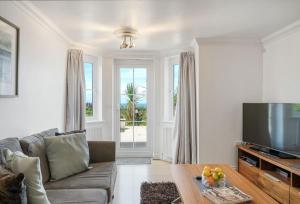 a living room with a couch and a television at Blue Horizon in Carbis Bay