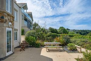 a patio with a table and benches in front of a building at Blue Horizon in Carbis Bay