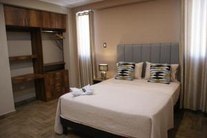 a bedroom with a bed with two white flowers on it at Hotel Campestre Casa Laredo in Chao
