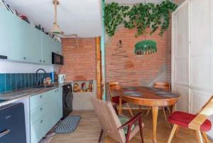 Una cocina con una mesa y una pared de ladrillos. en kushki's home, en Tiflis 19 fotos más