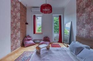 Un dormitorio con una cama grande y dos ventanas. en kushki's home, en Tiflis