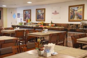 un restaurante con mesas, sillas y una barra en Profissionalle Hotel São Luís, en São Luís