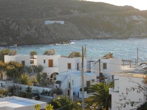 un groupe de bâtiments blancs à côté de l'océan dans l'établissement Yvonni Studios, à Patmos