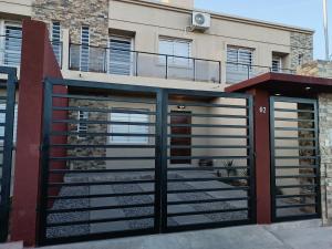 ein Garagentor aus Metall mit einem Balkon an einem Gebäude in der Unterkunft Duplex Los Perales in San Salvador de Jujuy