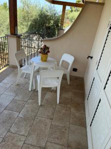 a patio with white chairs and a table at Villa Valentina in Cefalù