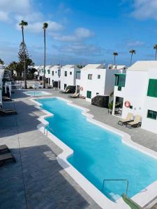 a large swimming pool in a resort with white buildings at Casa Adelfa in Puerto del Carmen
