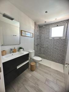 a bathroom with a toilet and a sink and a tub at Casa Adelfa in Puerto del Carmen