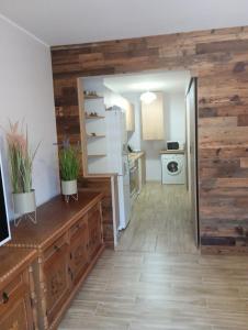 Il comprend une cuisine avec des murs en bois et un réfrigérateur. dans l'établissement Apartament Osiedle Bajkowe, à Ostrów Wielkopolski