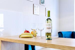 Una botella de vino y dos copas en una mesa. en Apartament Wiedeński de LUX, en Bielsko-Biala