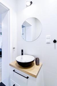 baño con espejo redondo y lavabo en Apartament Wiedeński de LUX, en Bielsko-Biala