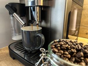 a coffee maker and a bowl of coffee beans at Bursztyn Apartament in Zator