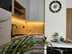 a kitchen with a clock on the wall and a table at Bursztyn Apartament in Zator