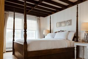 a bedroom with a four poster bed and a large window at Mysa Nordic Spa & Resort in Saint Peters