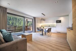 sala de estar con sofá y mesa con sillas en Apartments Chalet Silva en Selva di Val Gardena
