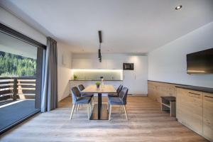 Apartments Chalet Silva في سيلفا دي فال جاردينا: غرفة طعام ومطبخ مع طاولة وكراسي