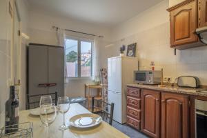 uma cozinha com uma mesa e um frigorífico em Casa Monte no Funchal