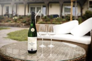 a bottle of wine sitting on a table with two wine glasses at Ferien Weingut Schneider in Ellenz-Poltersdorf