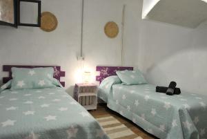a bedroom with two beds and a night stand at Casa del silencio Can Baldoyra in Espinavesa