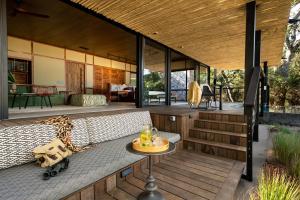 a house on a deck with a couch and a table at Tanda Tula Safari Camp in Timbavati Game Reserve