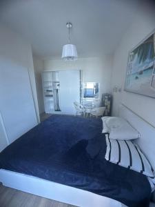 a bedroom with a large bed with a blue blanket at Family Inn in Gonio