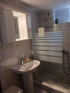 y baño blanco con lavabo y ducha. en Vivari's Family House, en Nauplia
