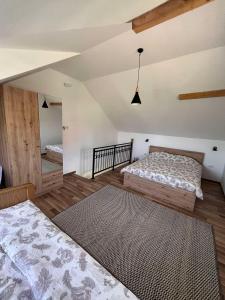 1 Schlafzimmer mit 2 Betten in einem Zimmer mit Holzböden in der Unterkunft Zlatna Jabuka apartman in Prijepolje