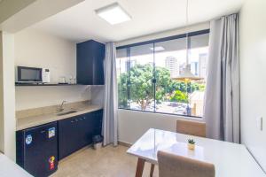 uma pequena cozinha com uma mesa e uma janela em GARVEY FLAT em Brasília