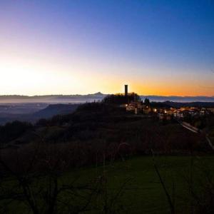 Blick auf einen Hügel mit einem Turm bei Sonnenuntergang in der Unterkunft Peter Pan in Castellino Tanaro
