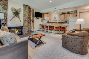 a living room with a fireplace and a kitchen at Laurelwood Condominiums 406 in Snowmass Village