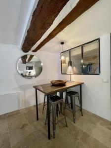 - une salle à manger avec une table et deux tabourets dans l'établissement Appartement de charme centre historique d'Aix-en-Provence, à Aix-en-Provence