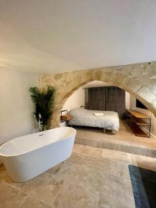 La grande salle de bains est pourvue d'une baignoire et d'un lit. dans l'établissement Appartement de charme centre historique d'Aix-en-Provence, à Aix-en-Provence