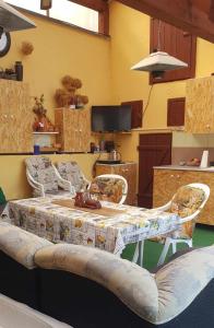 a table with two chairs in a room with a kitchen at Rózsa apartman in Odorheiu Secuiesc