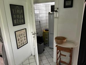 a bathroom with a door to a kitchen with a sink at Hexenhäuschen Wankendorf in Wankendorf
