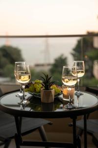 a table with three wine glasses and a plate of food at Luxury and Spa App F in Makarska