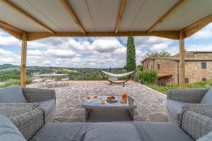 a patio with couches and a hammock on a patio at Villa Sunset in Greve in Chianti